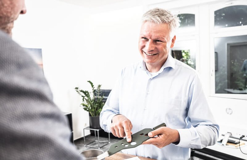 Ein Mitarbeiter von HÜNI+CO im Gespräch mit einem Kunden